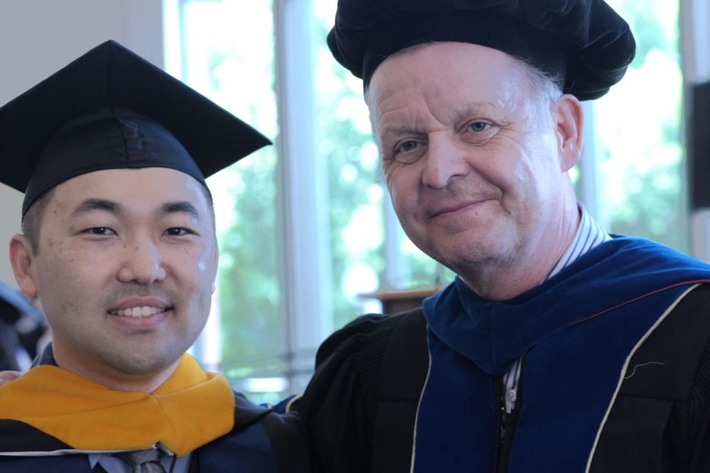 alt="Data Analytics Graduate student Tim and Dr Hans at the 2017 Graduation in commencement attire"