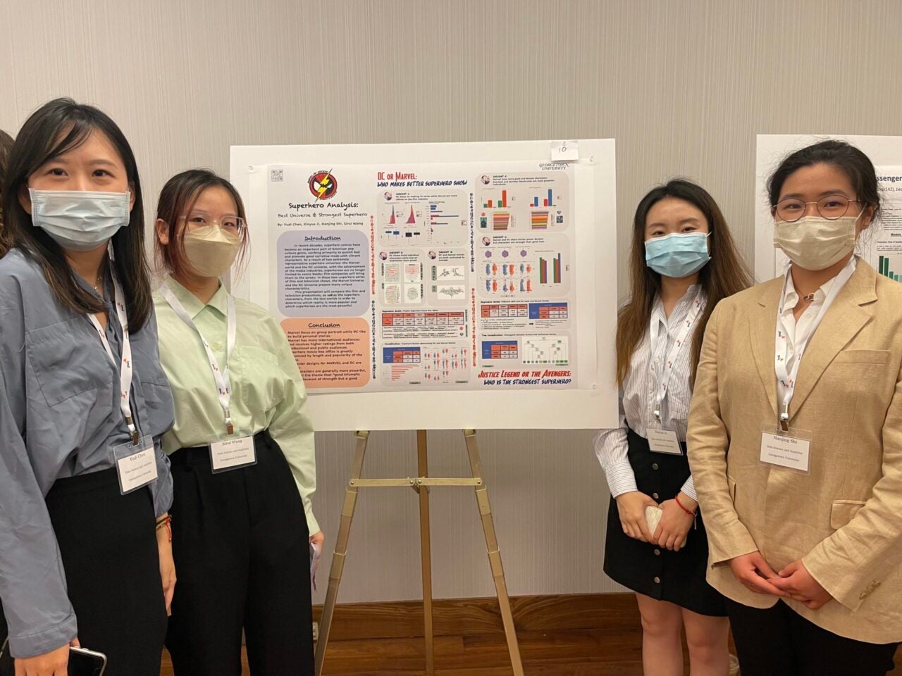 DSAN students stand on either side of the poster they are presenting