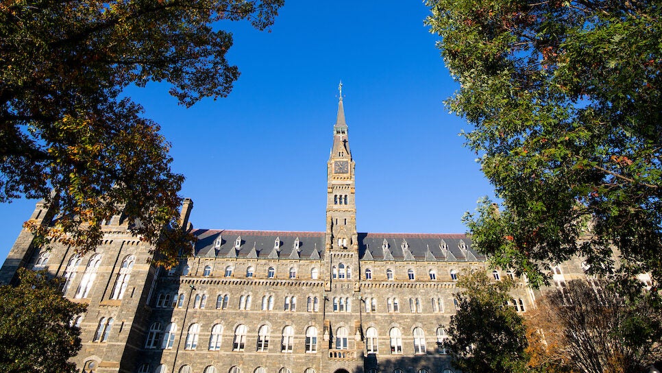 Healy Hall's bell tower framed by two green trees