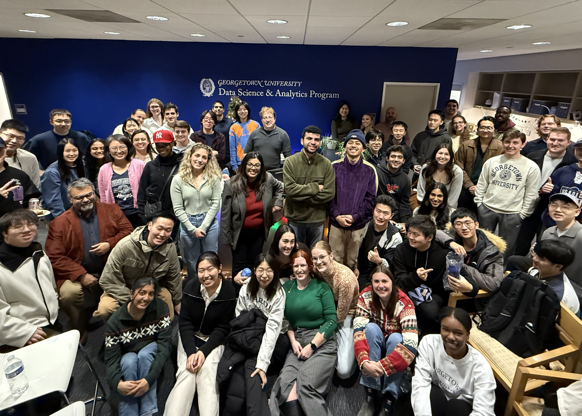 Group photo of a large number of DSAN Students in the DSAN Office Suite