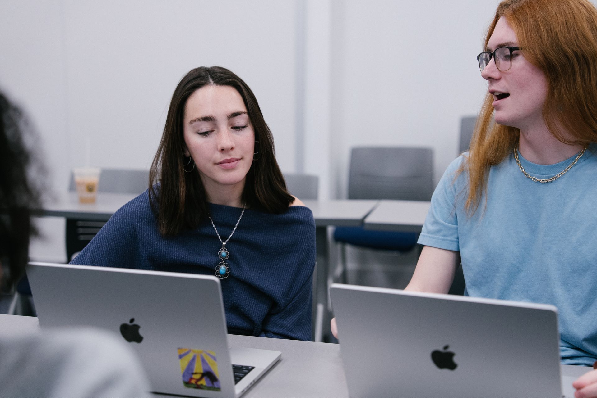 Two students looking at laptops together.