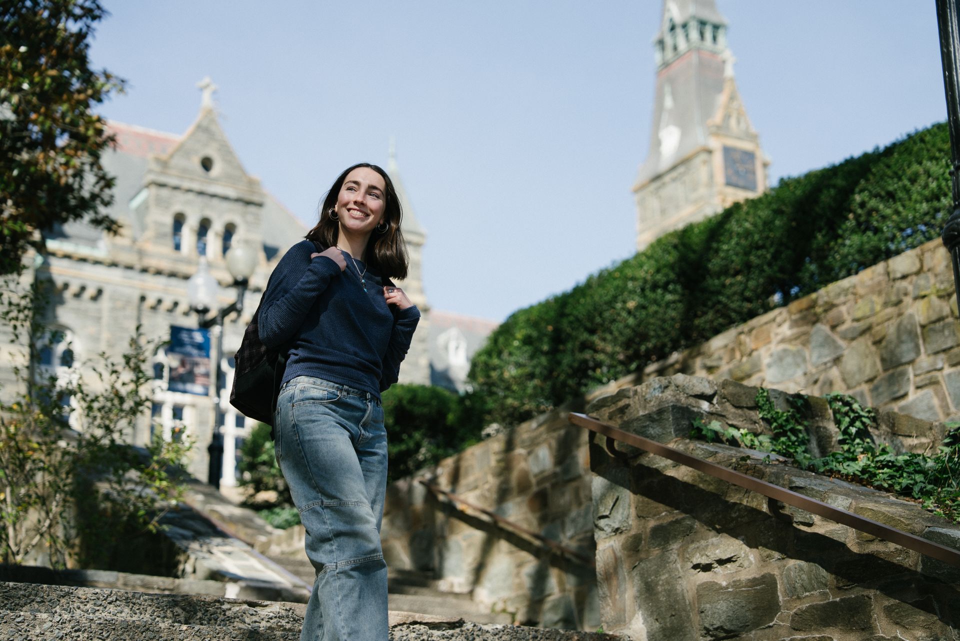 A student walks down steps outside on main campus.