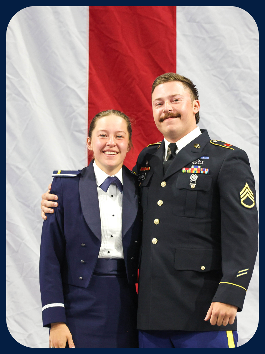 Erin B. and officer standing in front of a red and white striped background in uniform.