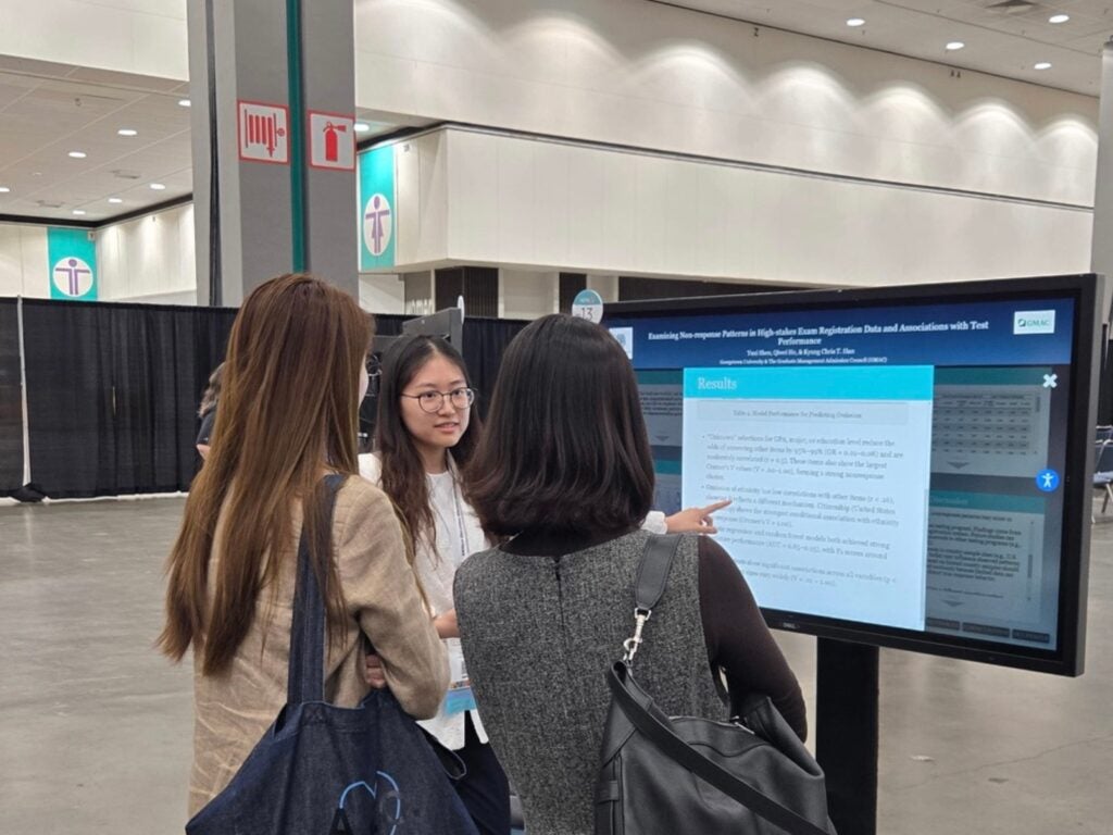 Yuxi presenting her digital poster to two other AERA attendees