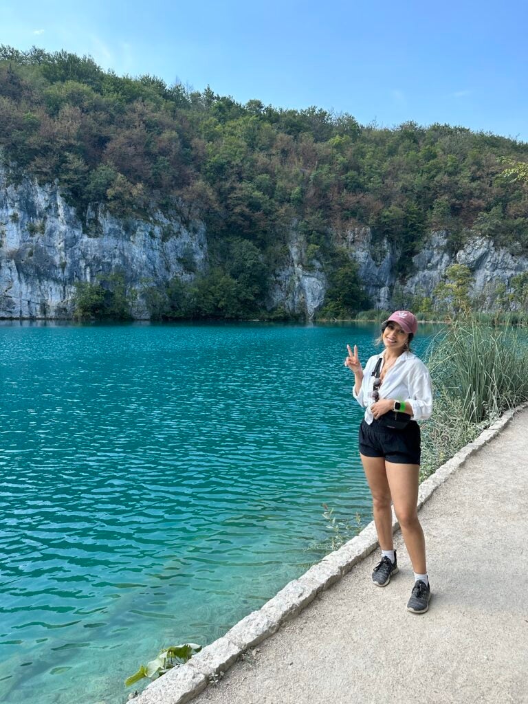 Fareeza standing on the edge of the water at a beach